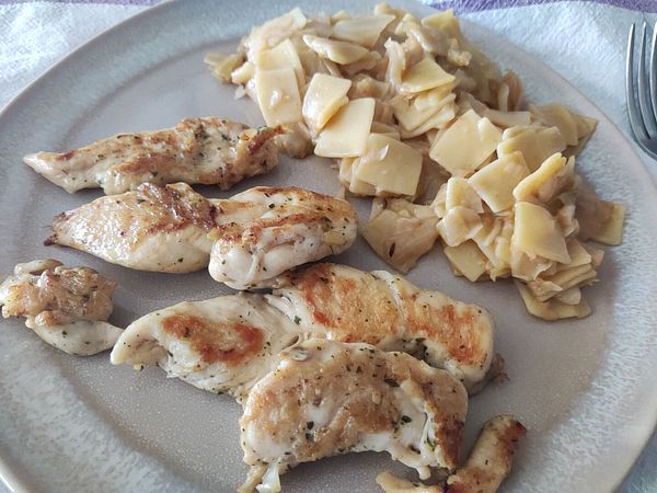 A plate featuring grilled chicken and krpice, a traditional Croatian dish.