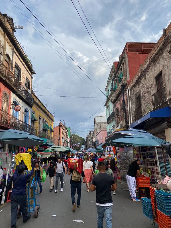 A bustling street scene in Mexico City filled with vendors and pedestrians.