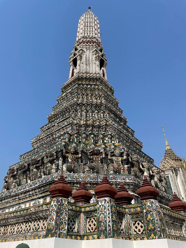 A beautifully ornate temple structure with intricate details and vibrant colors against a clear blue sky.