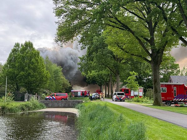A significant fire is engulfing a house in a residential area, with emergency services responding.