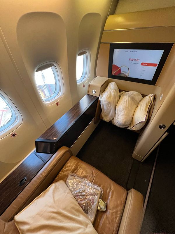 The image depicts a luxurious airplane cabin interior featuring a spacious seat area.