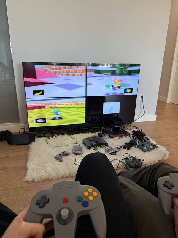 A cozy gaming setup featuring a large TV displaying a multiplayer game with two players holding controllers.