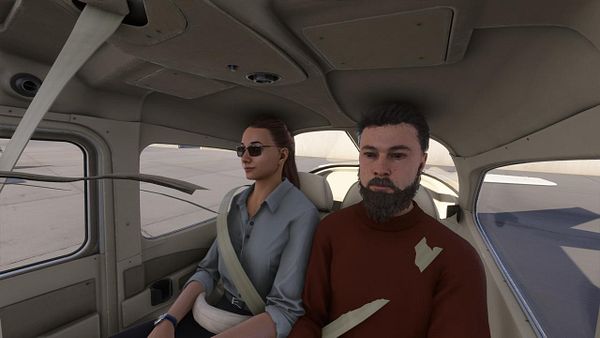 A man and a woman are seated inside a small aircraft, preparing for a flight.
