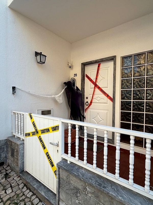 A spooky Halloween-themed entrance featuring a ghostly figure and caution tape.