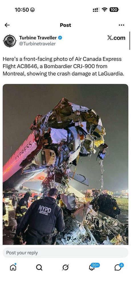 A city aerial nighttime view of an Air Canada aircraft on the runway surrounded by airport vehicles and lights.
