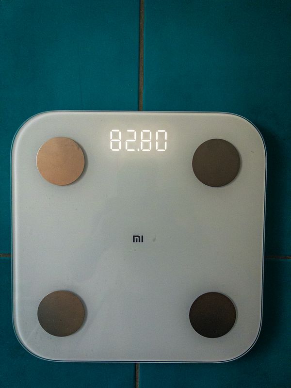 A close-up photo of a digital scale display showing a weight of 82.4 kg.
