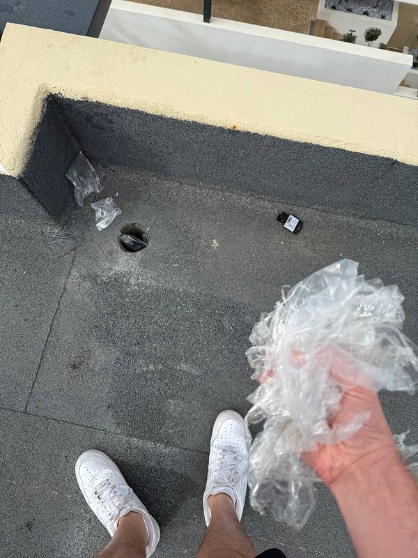 A person is cleaning up debris on a rooftop after solar panel installation.