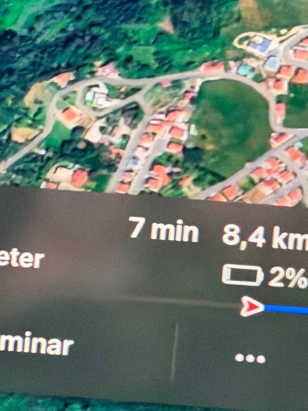 Smartphone screen showing a WhatsApp conversation about a car's battery charge during an Uber ride in Portugal.