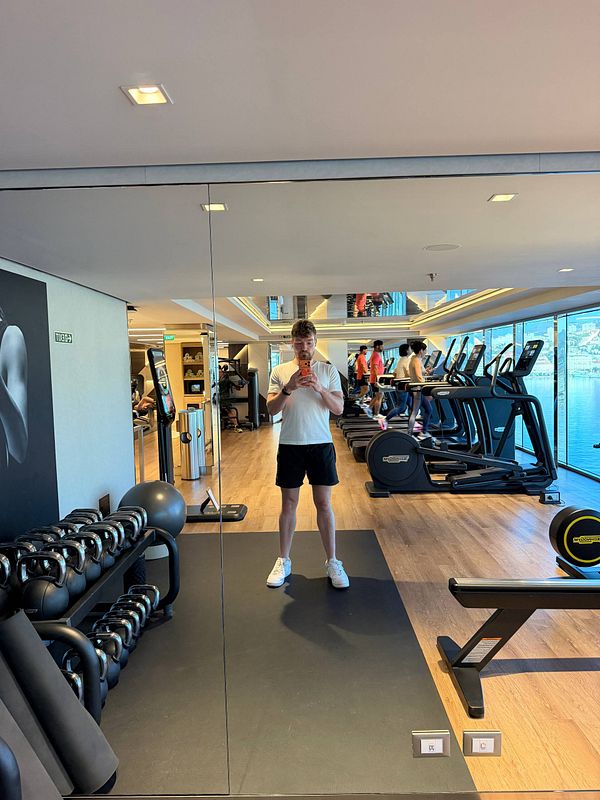 Photo of a fit woman in gym attire preparing to exercise in a gym setting.