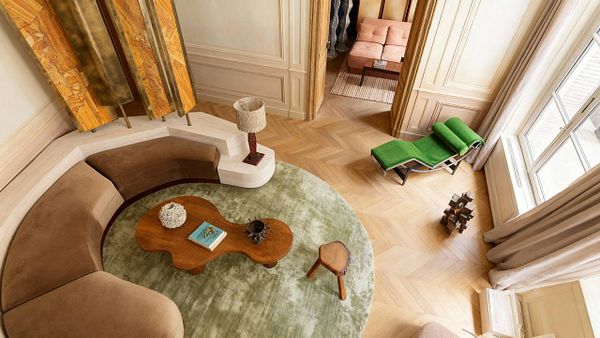 A stylish interior space featuring a curved sofa, a wooden coffee table, and various decorative elements.