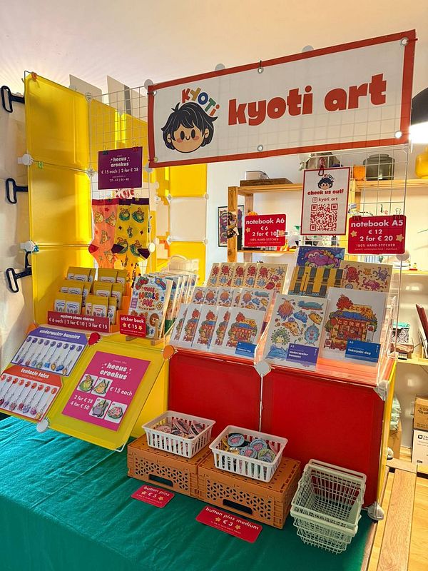 Corner booth setup featuring a display of various products including stationery and printed materials.