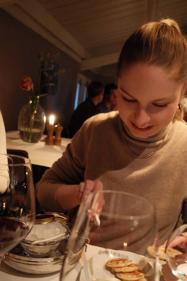 A woman enjoys a birthday dinner at a restaurant, focused on her meal.