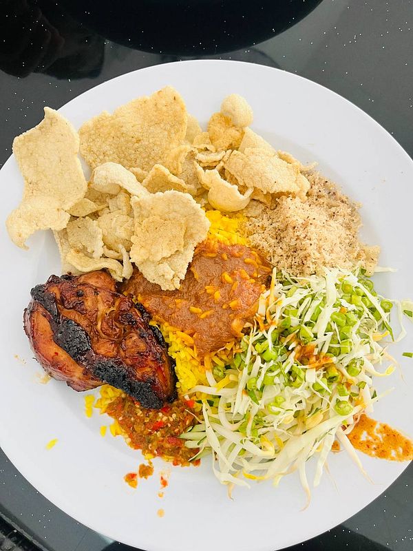 A plate of nasi kerabu featuring various traditional Malaysian dishes.