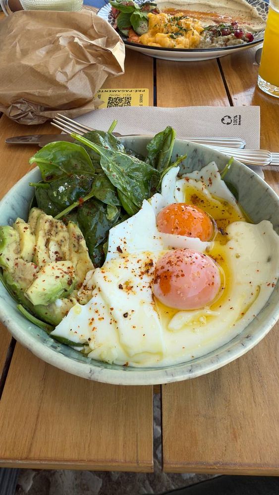 A delicious breakfast bowl featuring poached eggs, avocado, and spinach.