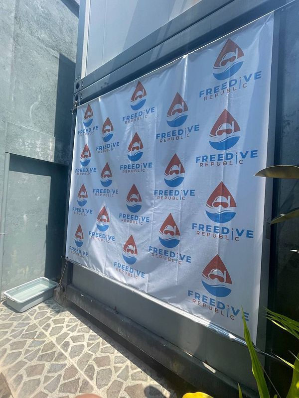 Woman freediver in bright blue wetsuit surrounded by clear ocean water.