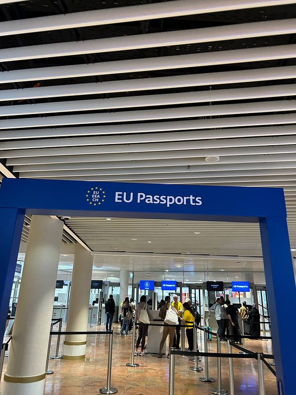 The image depicts the entrance to the EU Passports control area at an airport.