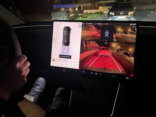The image displays a car's dashboard with a large touchscreen showing multiple camera views for parking assistance.