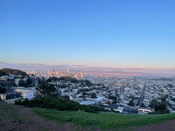 A panoramic view of San Francisco at sunset, showcasing the city skyline and surrounding neighborhoods.
