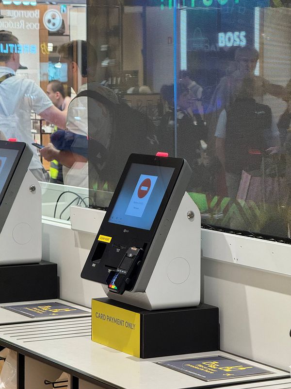 The image depicts a self-service kiosk at Lisbon Airport with a focus on payment options.