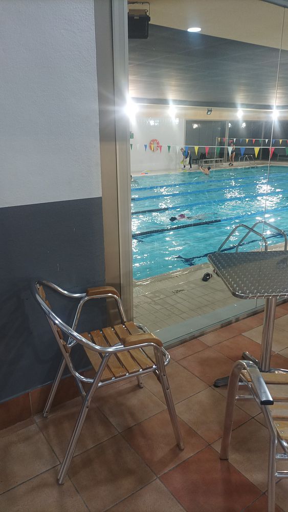 A mountain trail scene with a signpost and a cairn under dramatic cloudy sky conditions.