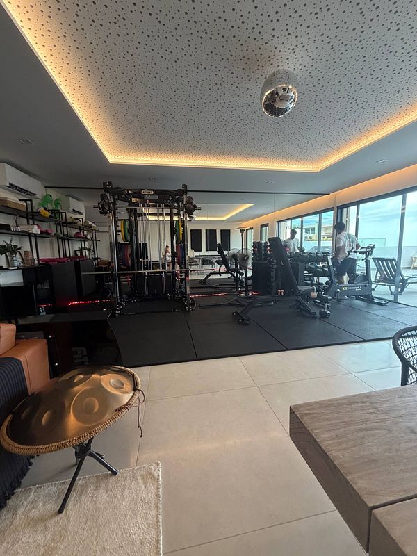 A modern home gym space with various workout equipment and a large mirror wall.