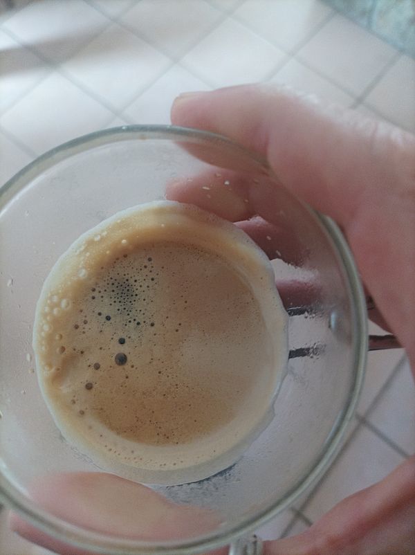 A close-up view of a glass containing freshly brewed espresso.