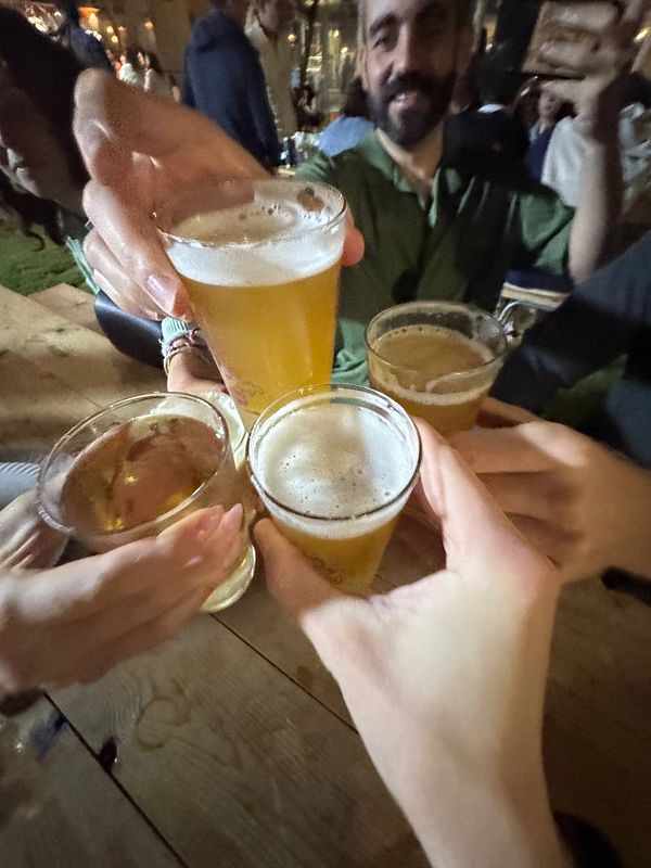 A group of people is toasting with various drinks at a festival.
