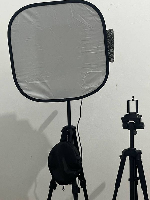 A softbox setup for LED lighting is prominently displayed alongside a tripod.