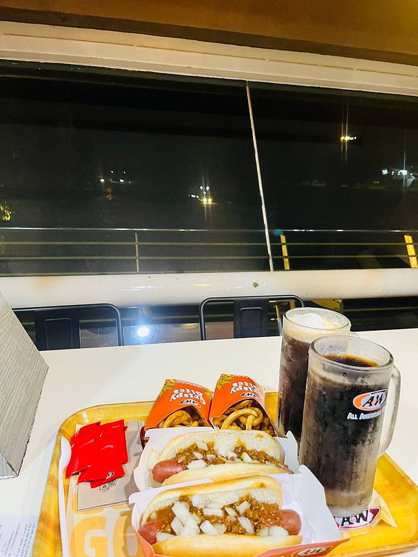 A tray of food featuring hot dogs, fries, and drinks at an A&W restaurant.
