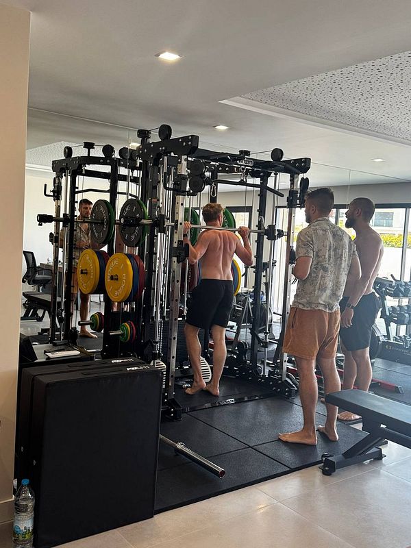 A group of men is engaged in a workout session at a gym.