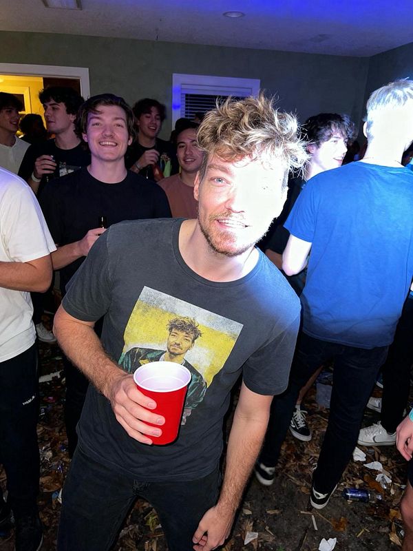 A lively party scene featuring a young man holding a red cup, surrounded by friends.