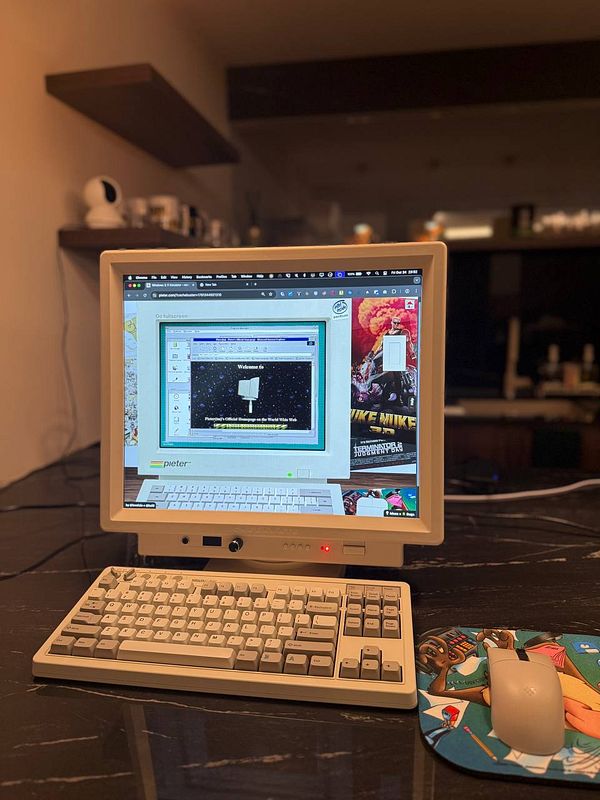 A vintage computer setup featuring a monitor displaying a web page for pieter.com.