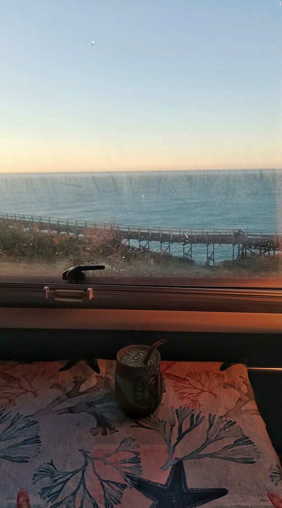 A cozy morning scene with a view of the ocean from a window.