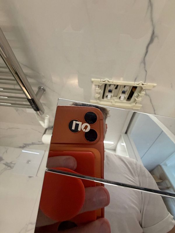 Toilet flush control system with buttons installed upside down inside a bathroom wall.