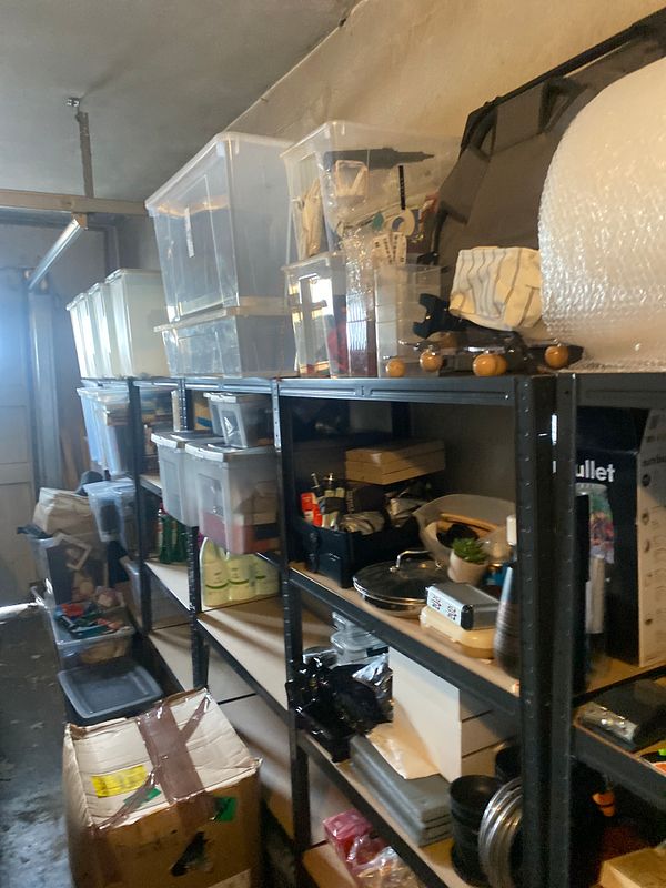 A clean and organized garage interior featuring neatly arranged shelves with various storage boxes and items.