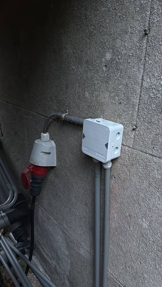 The image depicts electrical components mounted on a concrete wall for a DIY light installation.