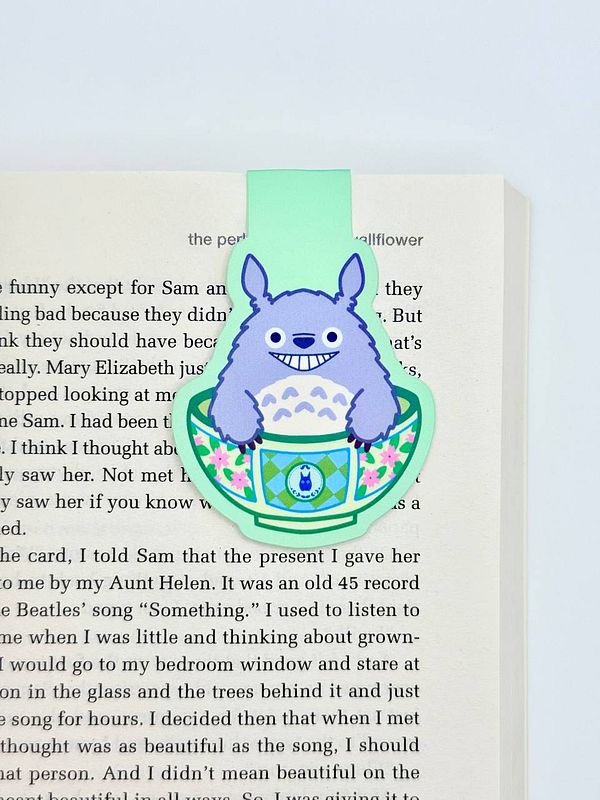 A colorful magnetic bookmark featuring a character from a popular animated film is placed on an open book page.
