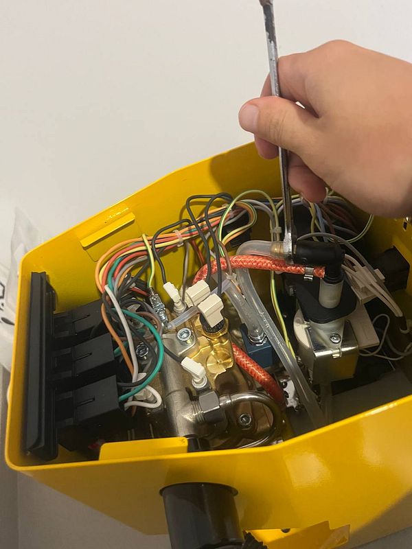 An open Gaggia Classic espresso machine is being modified with tools visible.