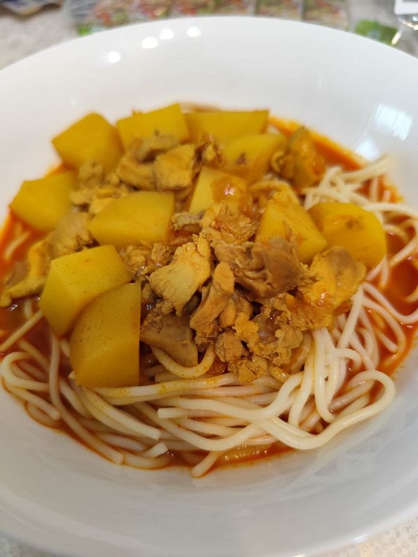 A bowl of curry mee featuring horse meat and diced potatoes.
