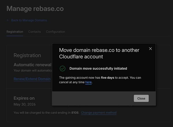 Close-up of a hand holding a black and white Rebase.co branded face mask.