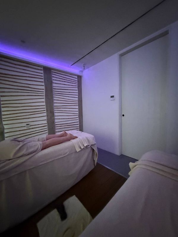 A serene massage room with soft lighting and two massage tables.