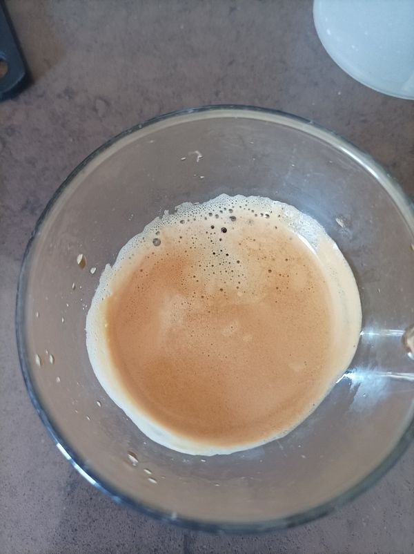 A close-up view of a glass containing freshly brewed espresso.