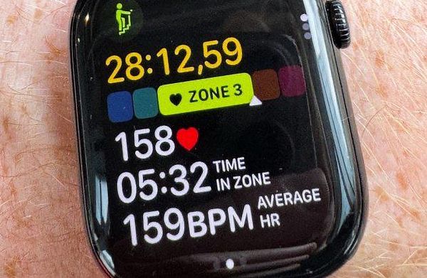 Photo of a person working out on a stairmaster machine in a spacious, well-lit gym.