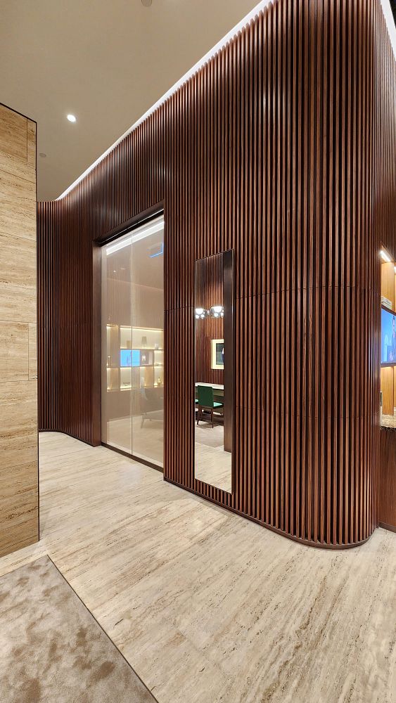 The image depicts the interior of a luxurious Rolex boutique featuring elegant wooden paneling and a polished floor.
