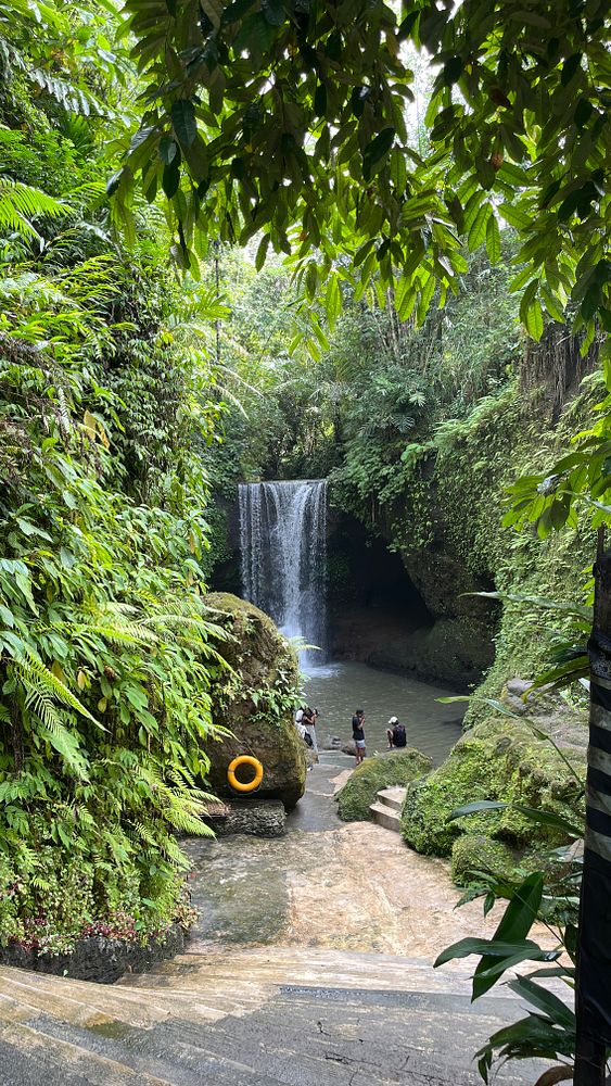 A serene waterfall surrounded by lush greenery in Ubud, Bali.