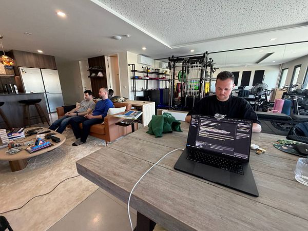 Cozy coworking space room with a person working on a laptop and a Corgi dog sitting nearby.