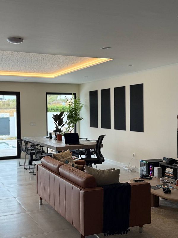 A modern coworking space featuring acoustic tiles, plants, and a stylish interior.