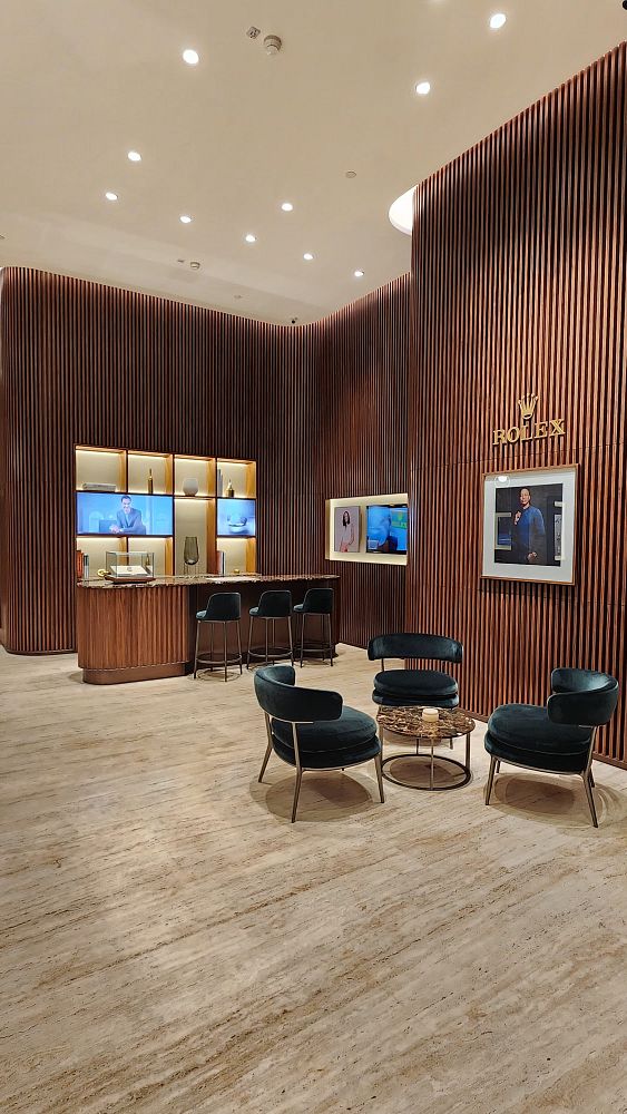 The image depicts the interior of a luxurious Rolex boutique featuring modern design elements.