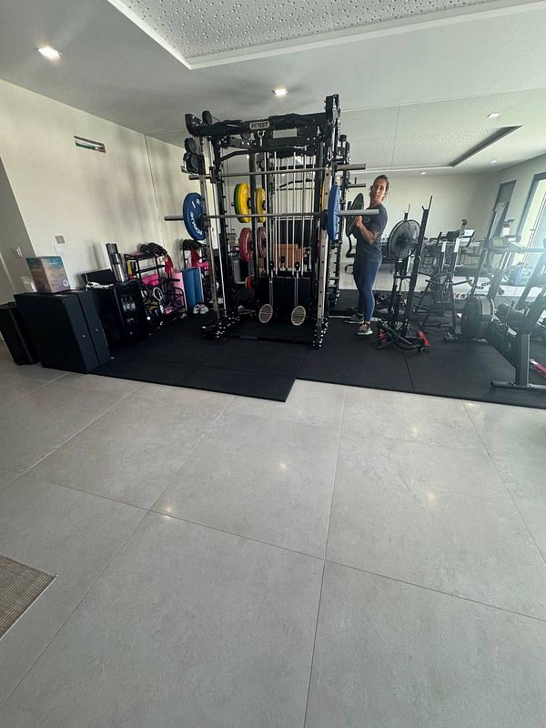 A personal training gym setup featuring various weightlifting equipment.
