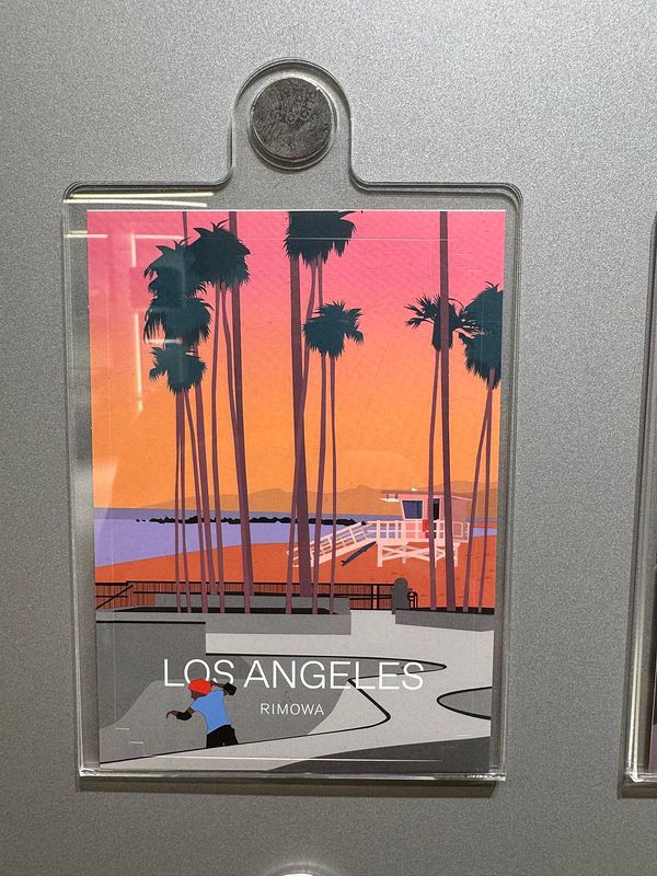 A colorful illustration of a beach scene in Los Angeles, featuring palm trees and a lifeguard tower.